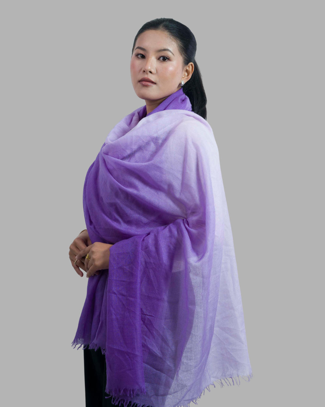 Woman wearing a purple scarf on a gray background